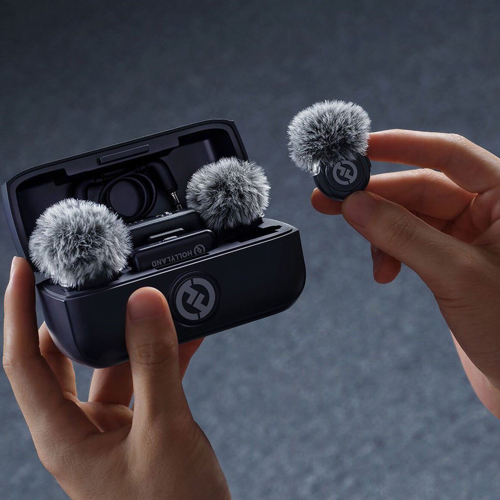 Hollyland Lark M3 charging case held in hand with transmitters and furry windshields