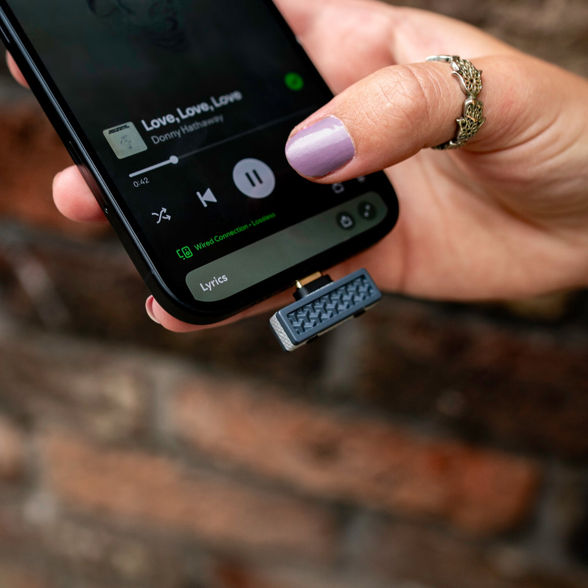 iFi Audio UP Play plugged into a smartphone held in hand