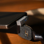 iFi Audio UP Play Max plugged into a smartphone beside wireless headphones