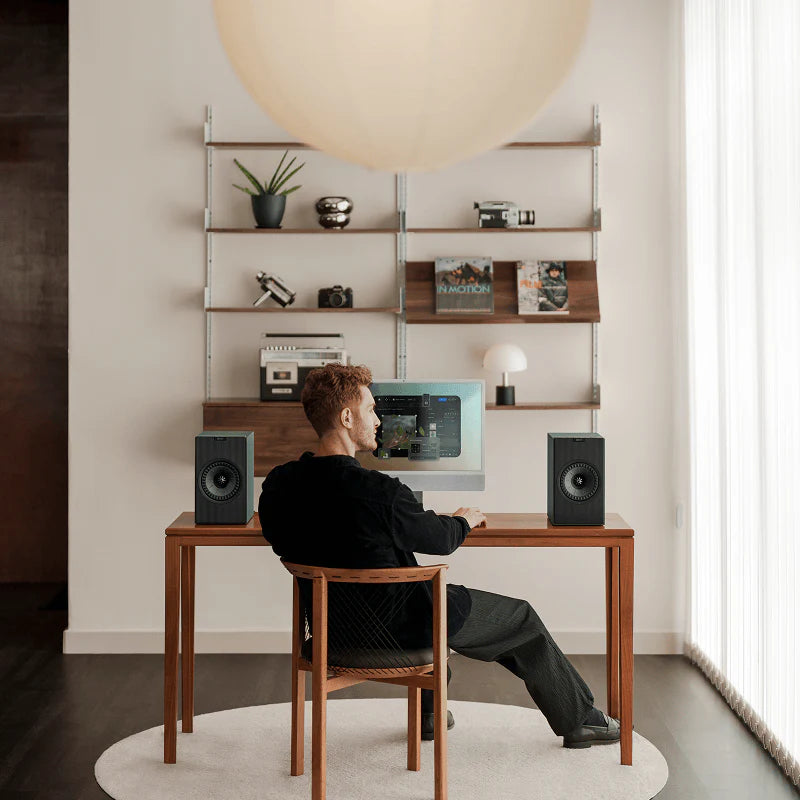 KEF Coda W active bookshelf speakers with sleek black cabinets and detailed driver grilles, designed for high-quality audio.