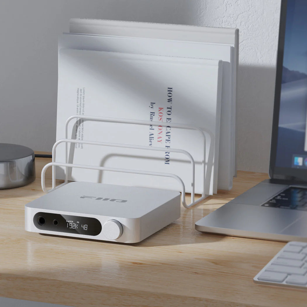 FiiO K11 headphone amplifier and DAC with sleek design, multiple ports, and control knobs for high-quality audio output.