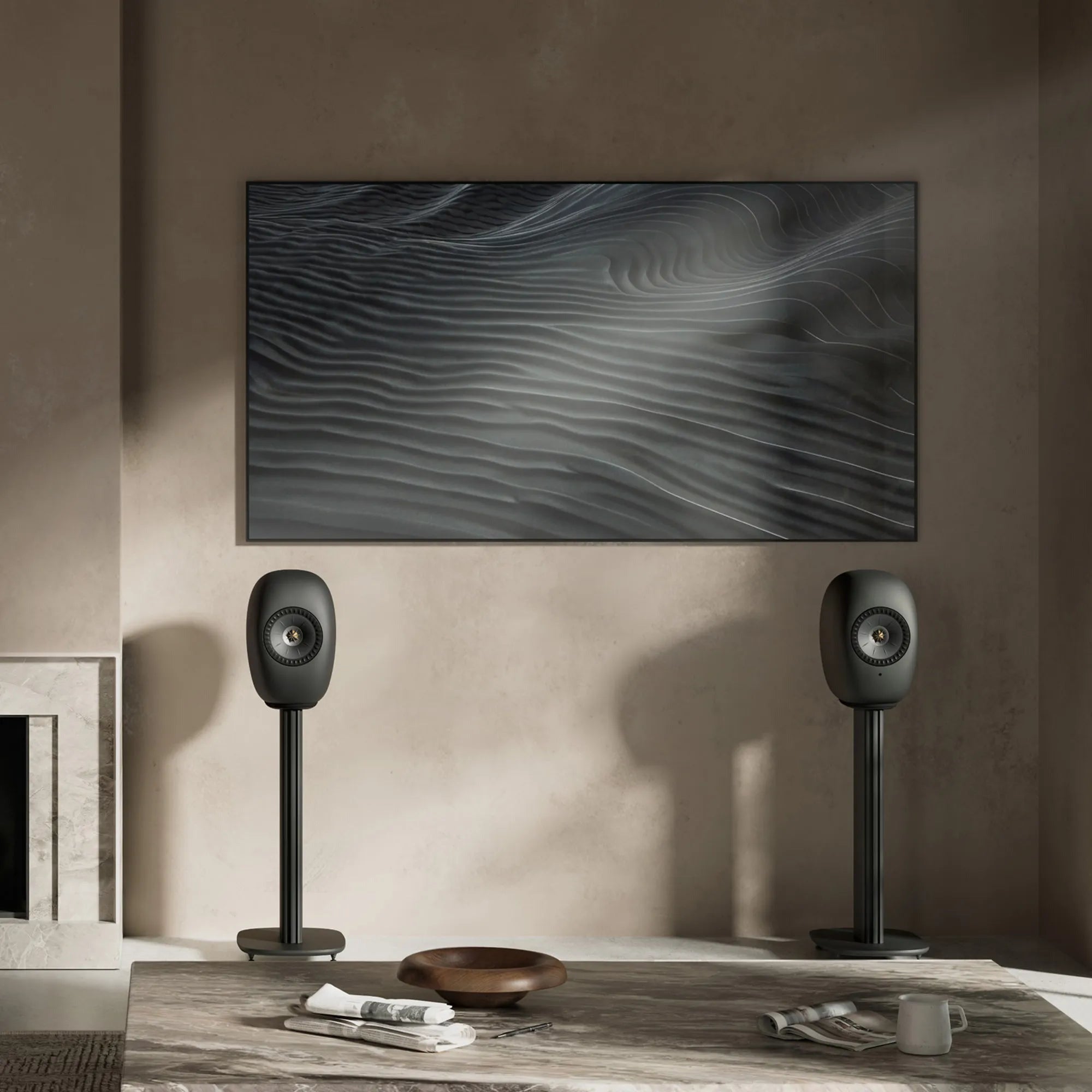 KEF LS Luxe in Eclipse Black on floor stands beside a wall-mounted TV in a plaster living room