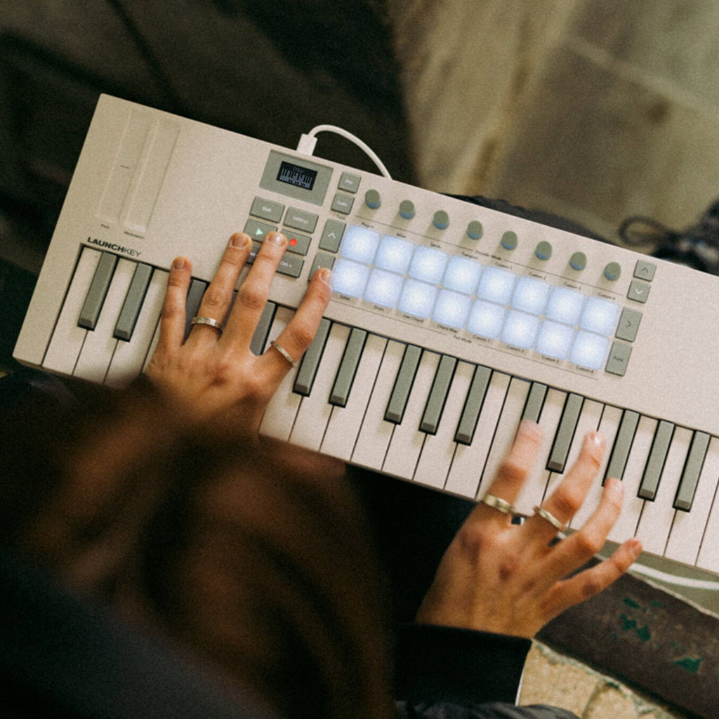 Novation Launchkey Mini 37 MK4 MIDI keyboard with compact design, keys, and control knobs, shown in a lifestyle setting.