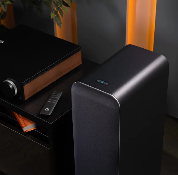 Q Acoustics M40 wireless speakers with sleek design and speaker grilles, showcasing their modern black finish and compact size.
