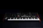 Moog Muse synthesizer with black background, featuring knobs, keys, and controls in a sleek electronic music instrument design