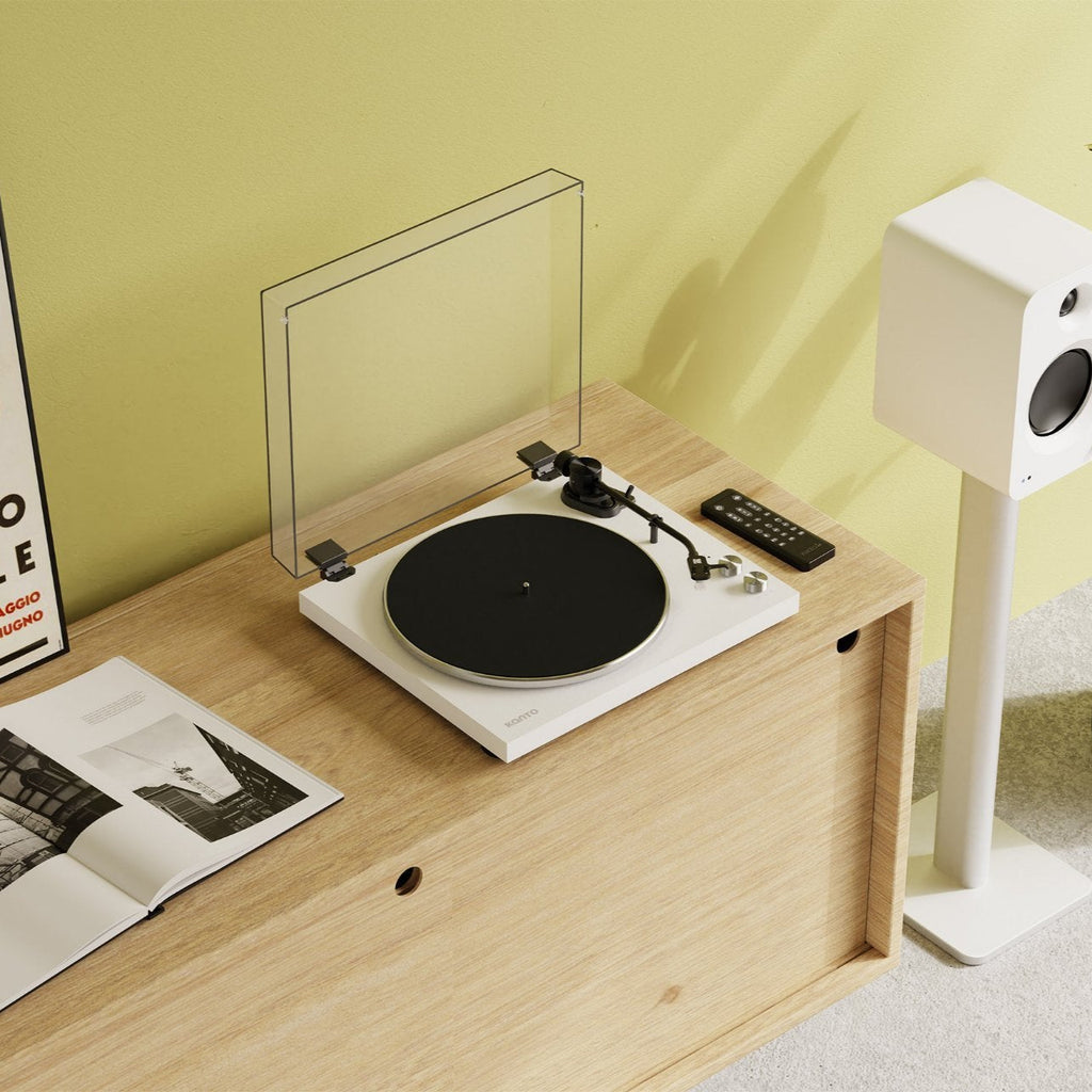 Kanto Audio OBI3 turntable with sleek black finish, placed on a modern wooden stand in a stylish living room setting.