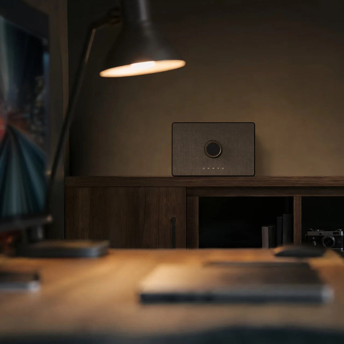 Onkyo GX-AiO wireless speaker on a sideboard