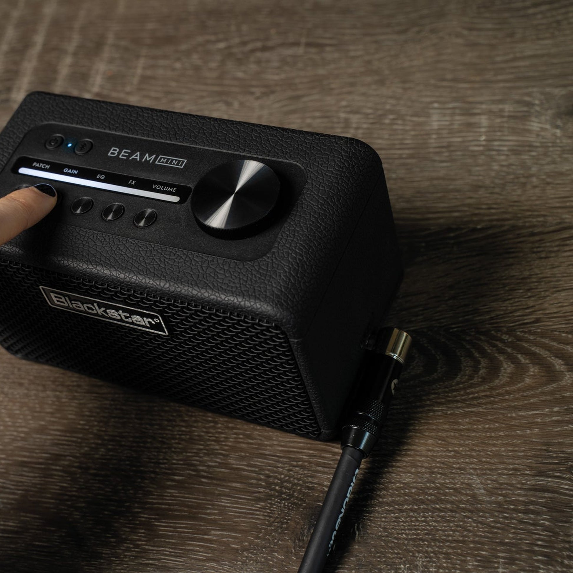 Blackstar Beam Mini on a wooden desk with a hand on the controls
