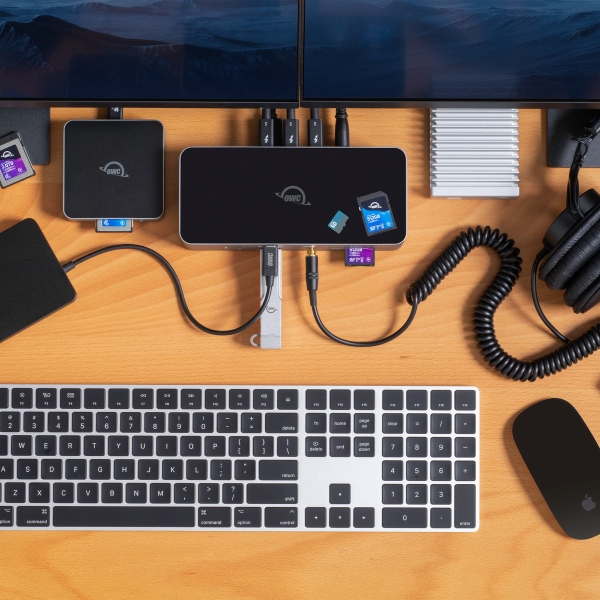 OWC Thunderbolt 5 Dock, top-down desk setup with keyboard, headphones and memory cards