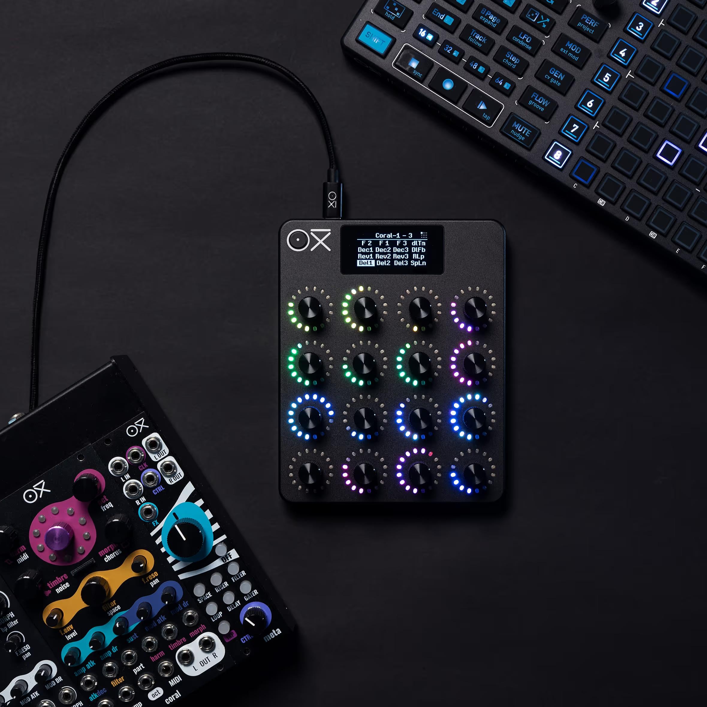 Group image of OXI Instruments E16 MIDI controller with multiple control knobs and buttons on a sleek black surface.