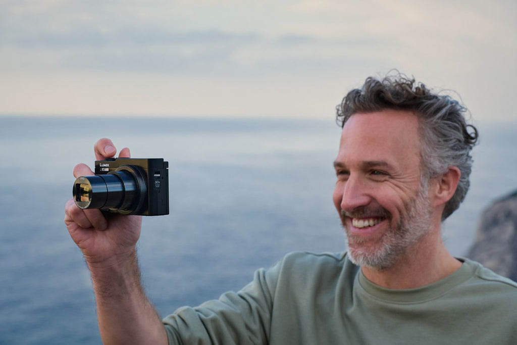 Black Panasonic Lumix TZ99 video camera with compact design and zoom lens, ideal for travel and high-quality video recording.