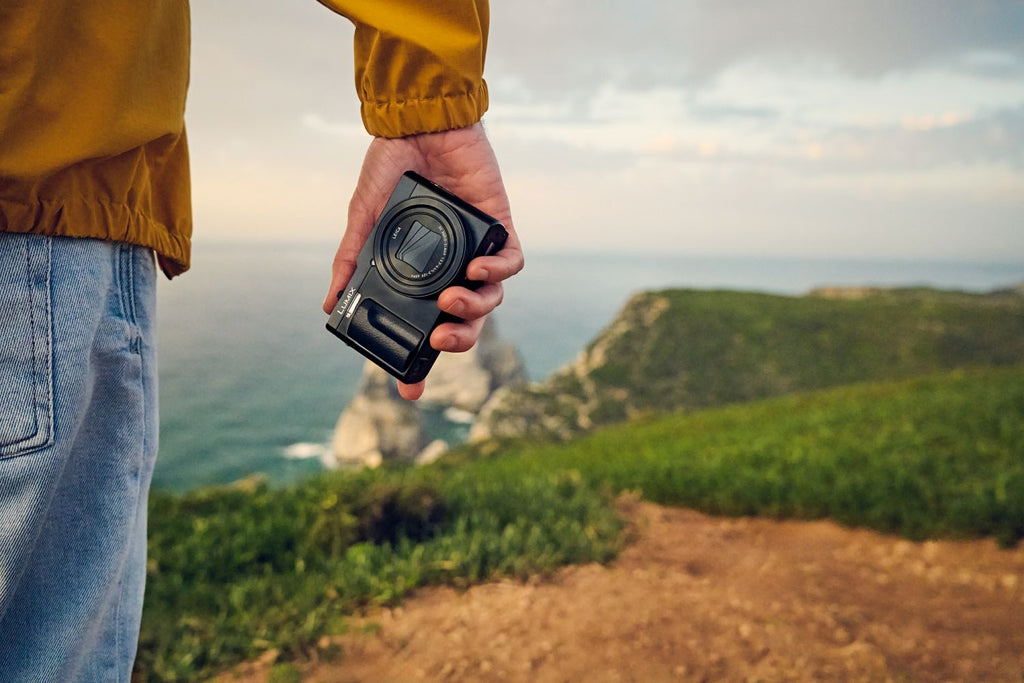 Black Panasonic Lumix TZ99 video camera with compact design and lens, ideal for travel and high-quality video recording.
