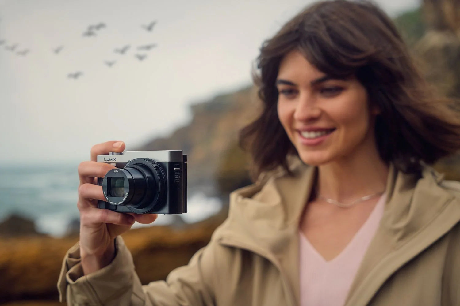 Panasonic Lumix TZ99 video camera in silver and black with zoom lens and compact design for travel recording.