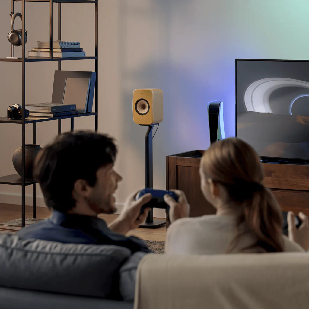 KEF LSX II active bookshelf speakers with sleek white finish and compact design, showing front grille and modern audio equipment.