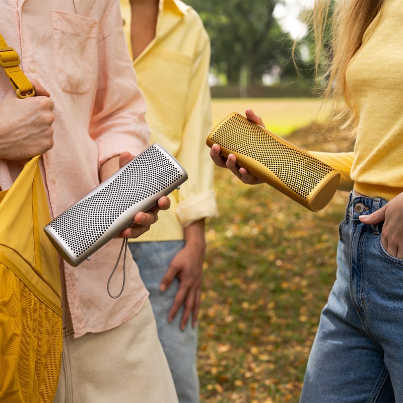 KEF Muo portable speaker in a lifestyle setting, showcasing its sleek design and compact size for on-the-go listening.