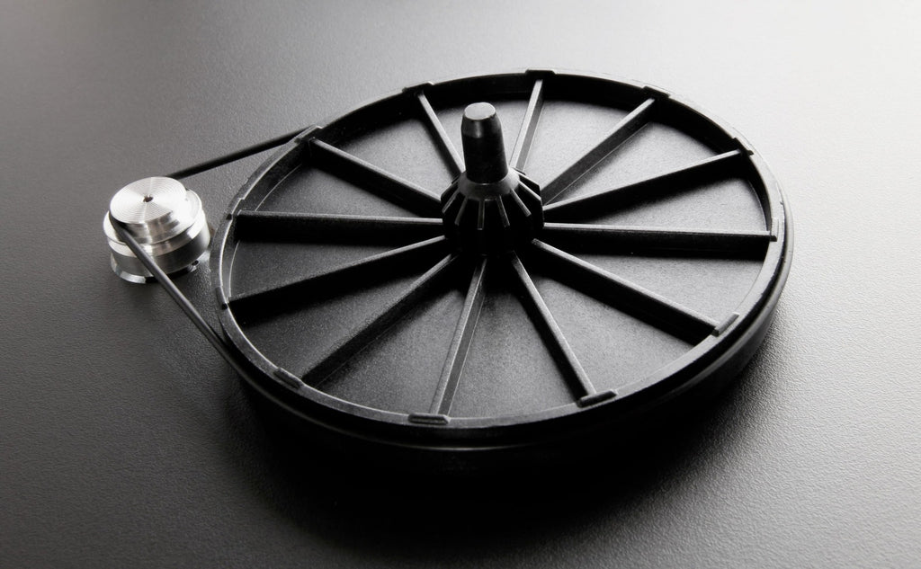 Rega Planar 1 turntable with matte finish, featuring a sleek design and tonearm, set against a neutral background.