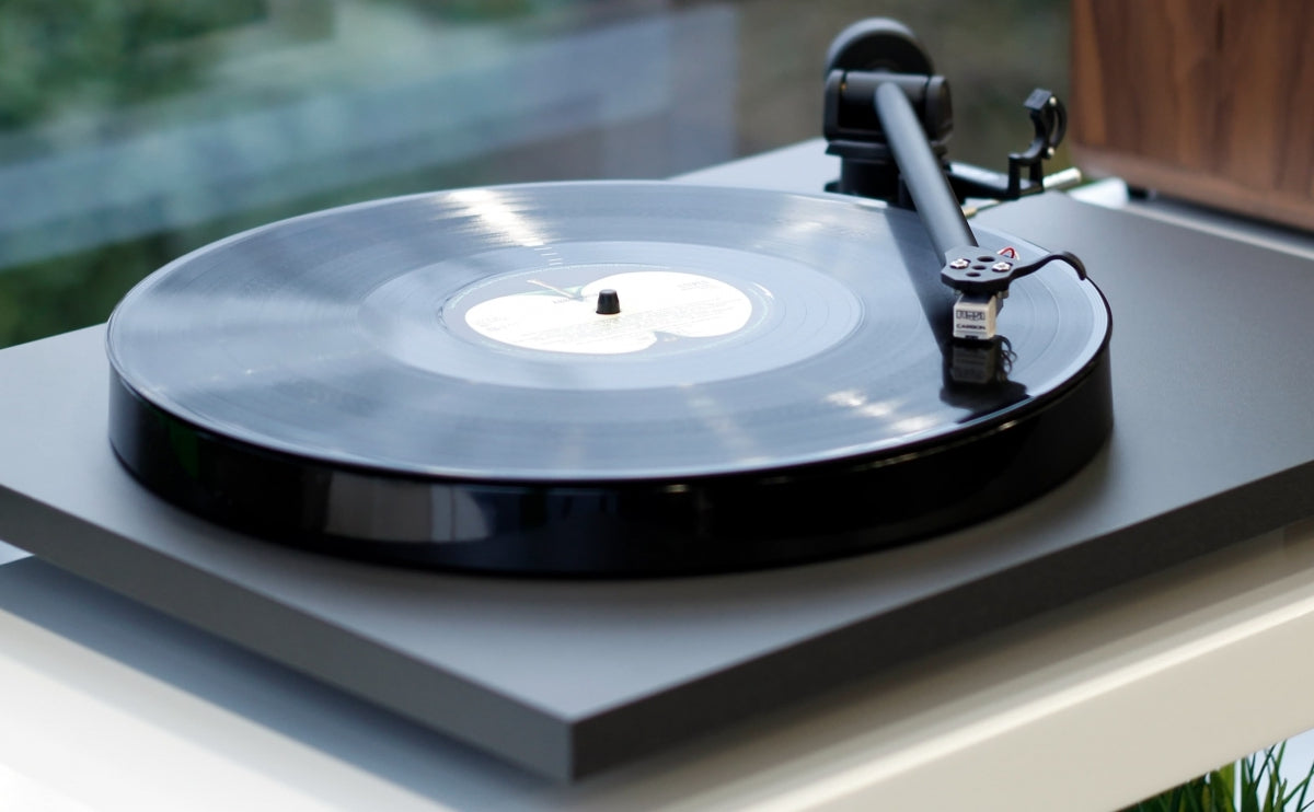 Rega Planar 1 matte finish turntable with sleek design and tonearm, showcasing its modern audio equipment features.
