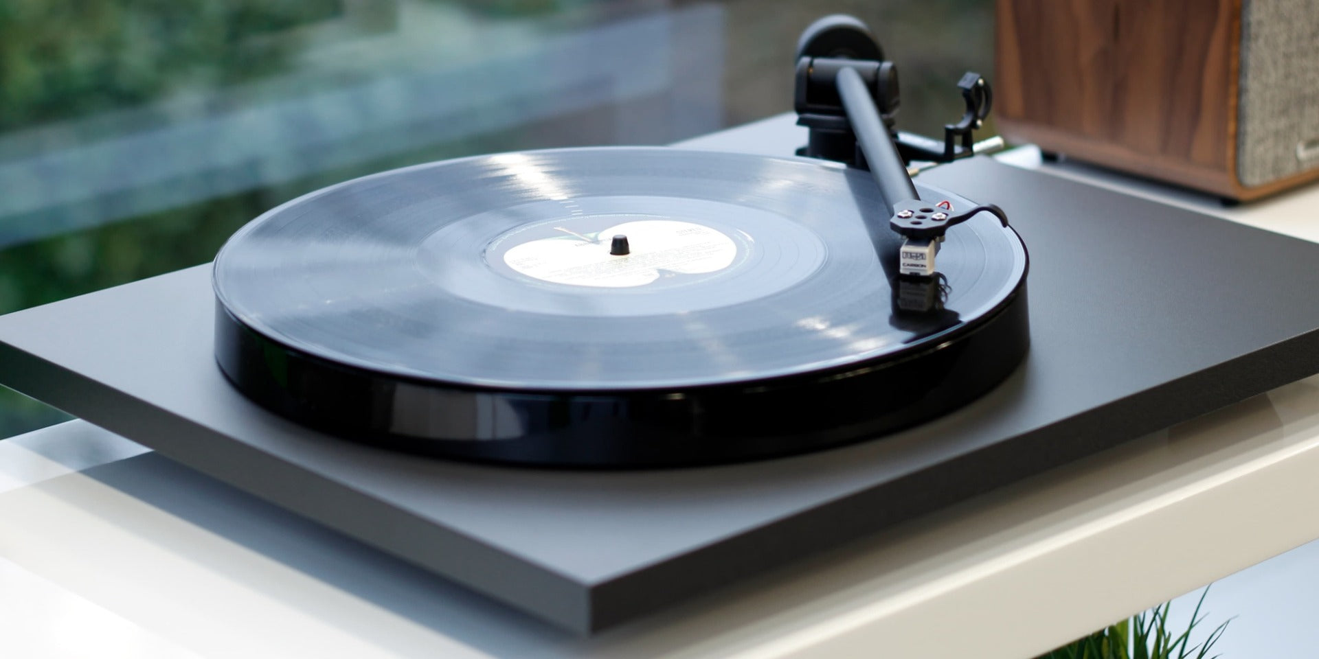 Rega Planar 1 Plus turntable with matte finish, featuring a sleek design and tonearm setup for high-quality vinyl playback.