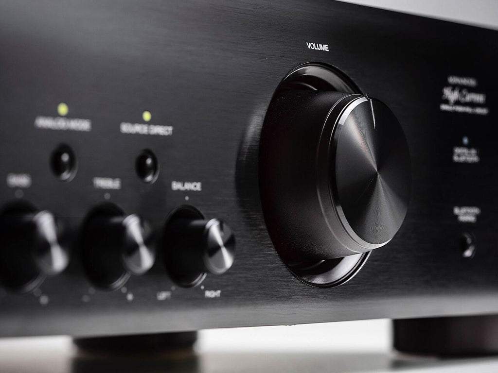 Denon PMA-600NE stereo amplifier with control knobs and silver finish on a modern audio setup.