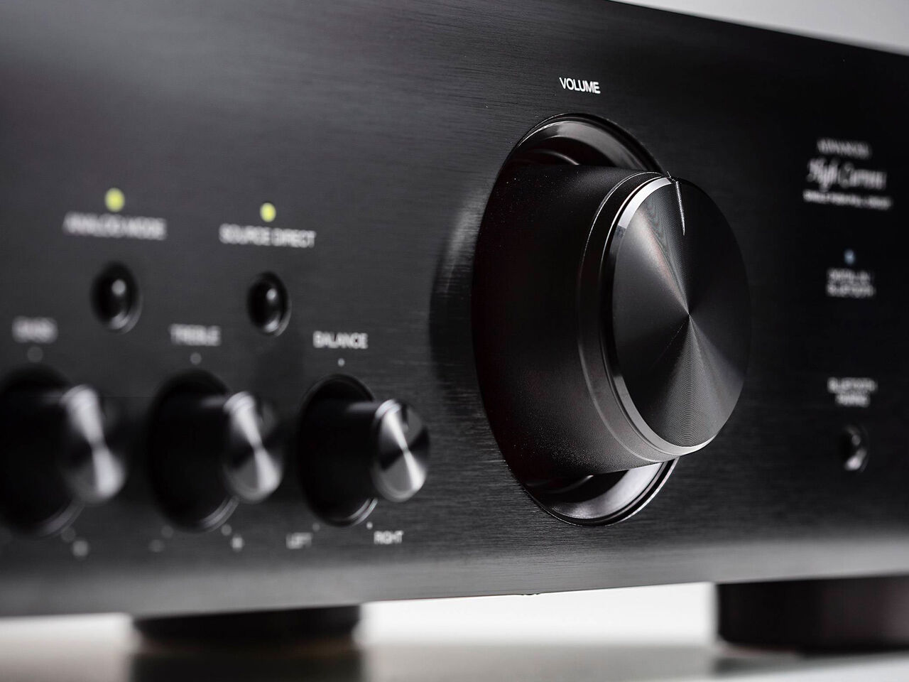 Denon PMA-600NE stereo amplifier with control knobs and silver finish on a modern audio setup.