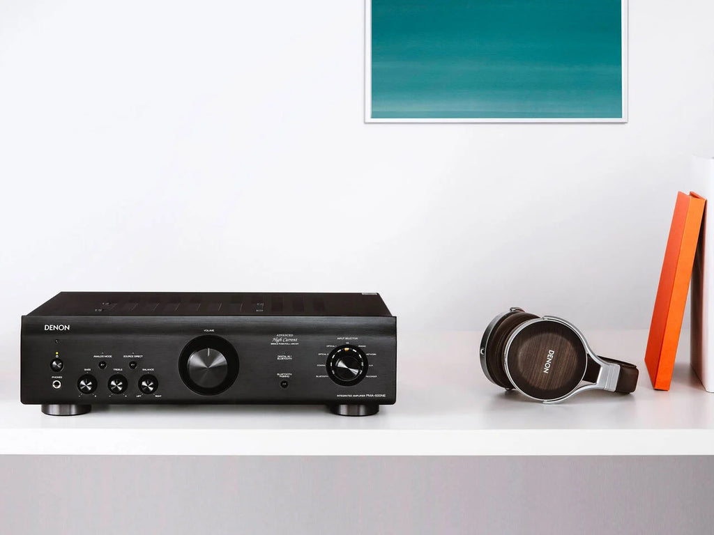 Denon PMA-600NE stereo amplifier with sleek black design and control knobs, set on a modern audio setup.