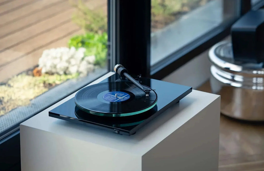 Pro-Ject T2 Super Phono turntable in black with a sleek design, shown in a lifestyle setting with tonearm and platter visible.