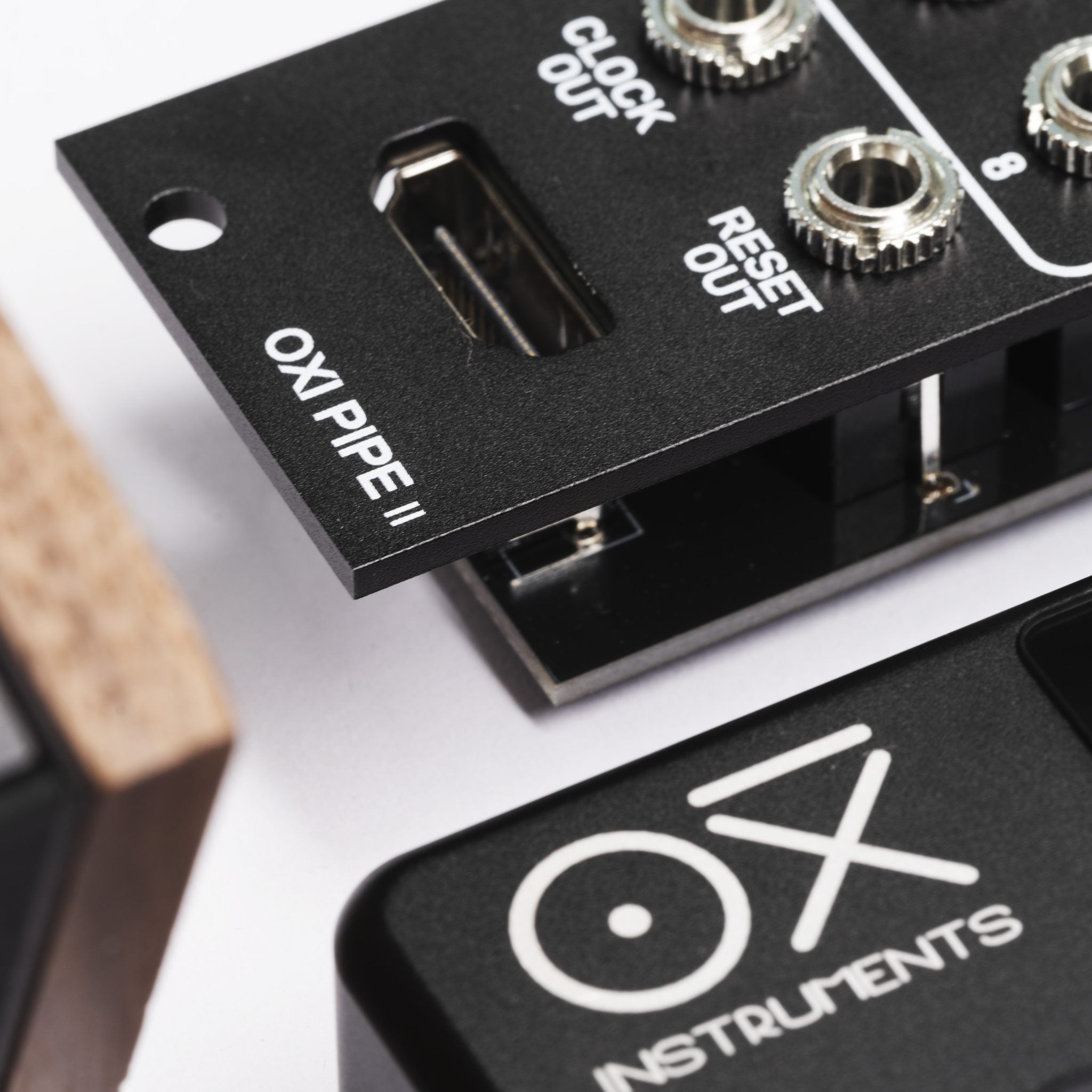 OXI Instruments Pipe MKII semi-modular synthesizer with various knobs and patch points, showcasing its sleek black design and control panel.