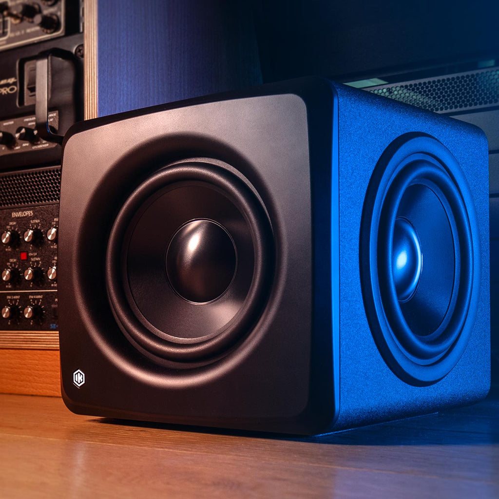IK Multimedia iLoud Subwoofer showing its compact design and front speaker grille for enhanced bass in a professional audio setup.