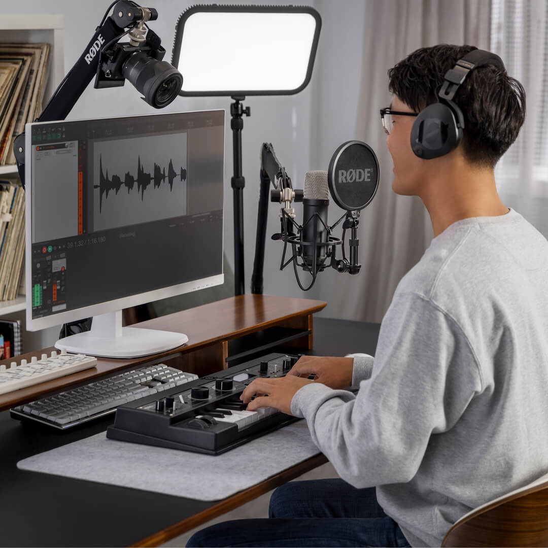 Rode NT1 GEN5 condenser microphone with black body and grille, positioned on a stand for studio recording or streaming.