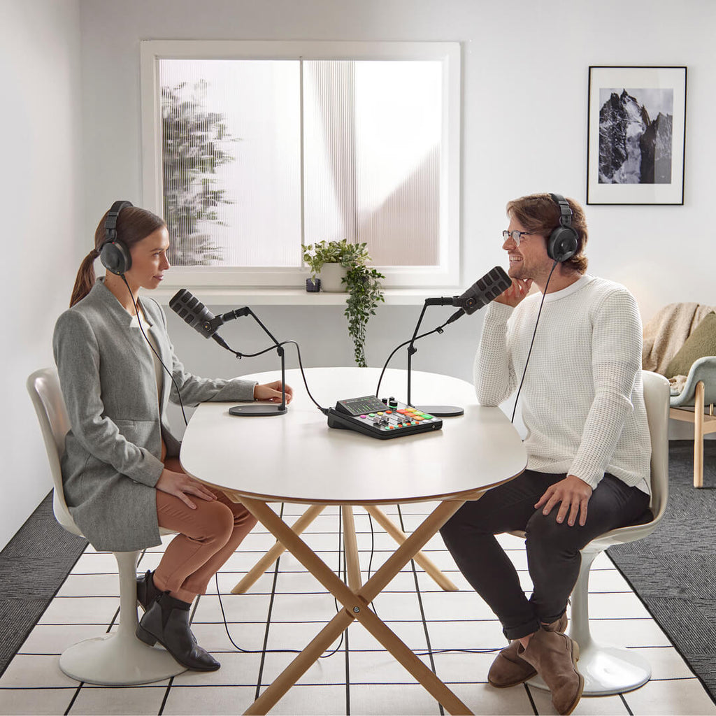 Rode RodeCaster DUO audio interface with microphones and studio setup for podcasting, featuring professional recording equipment.