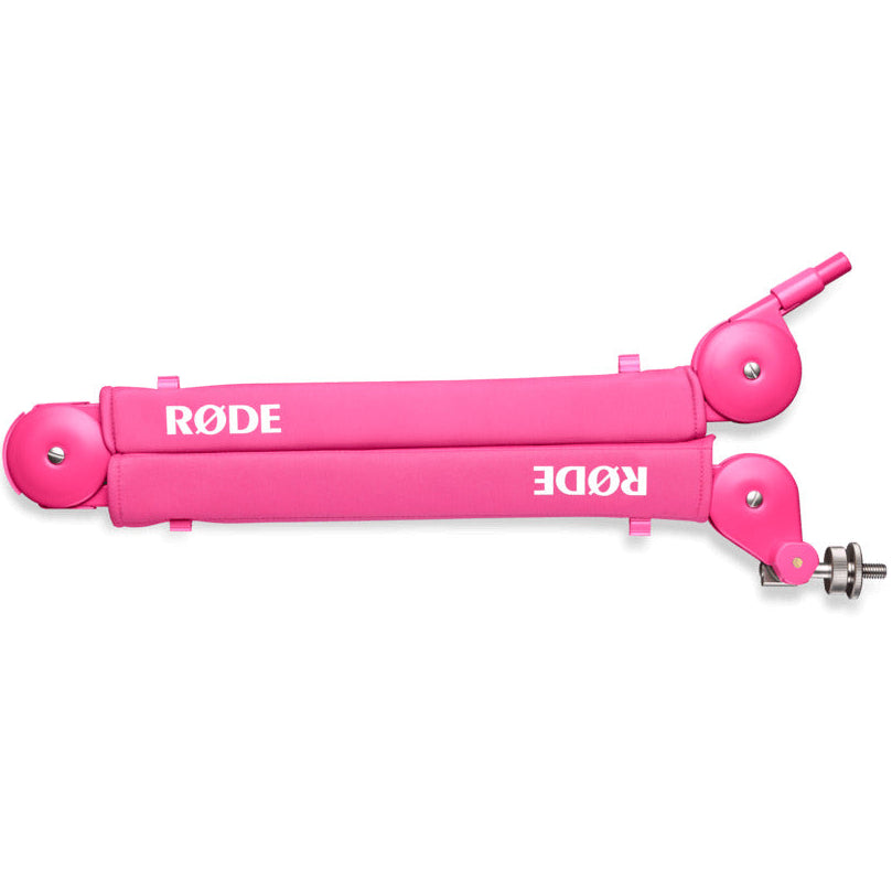 Pink Rode PSA1+ broadcast microphone arm mounted on a desk, showcasing adjustable arm with cable management features.