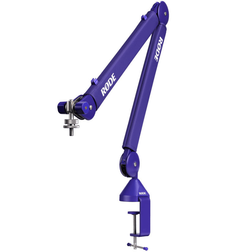 Rode PSA1+ broadcast microphone arm in purple, fully extended with adjustable joints, mounted on a desk for professional audio setup.