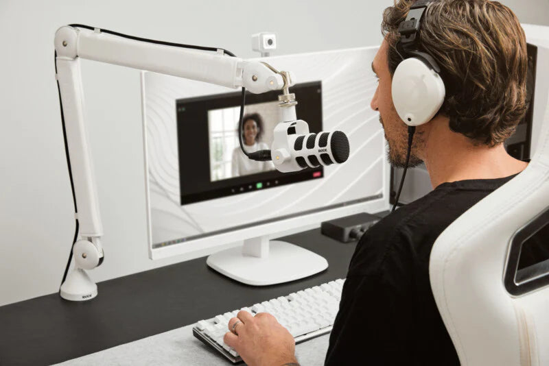 Rode PodMic dynamic microphone mounted on a stand with packaging, showcasing its professional broadcast design.
