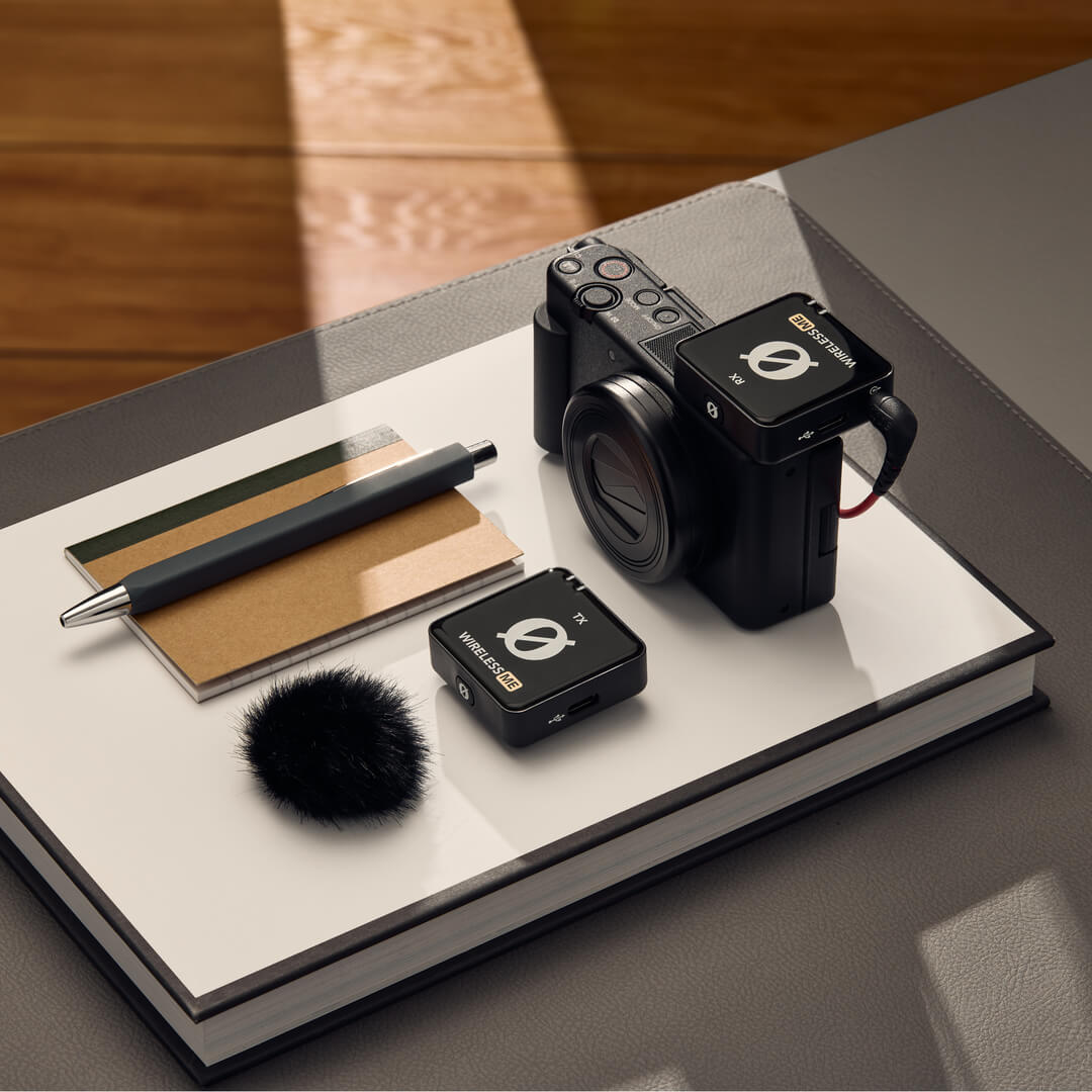 Rode Wireless ME creator wireless microphone system with receiver and transmitter, shown with camera accessories on a flatlay.