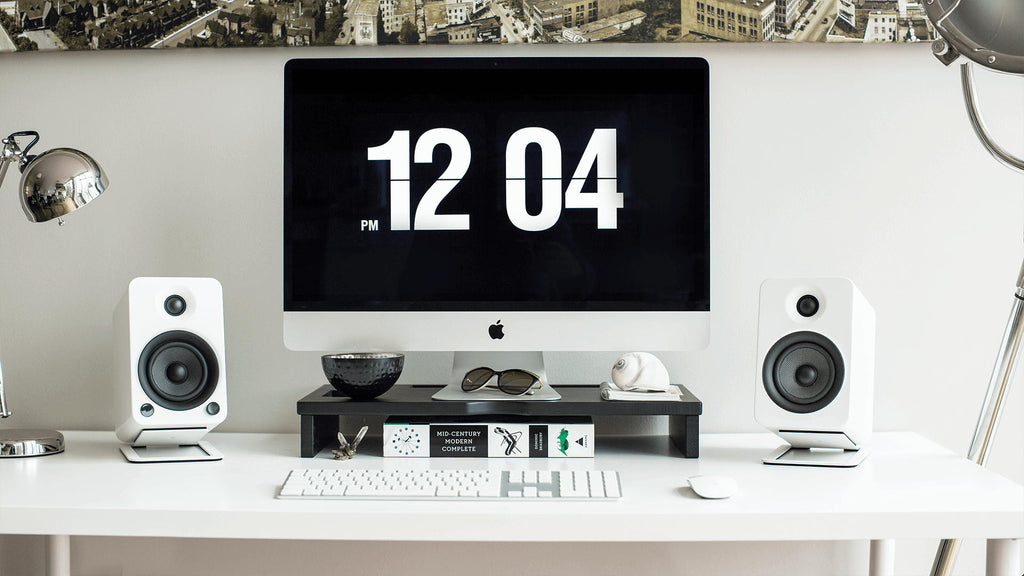 Kanto Audio S4 desktop speaker stands holding and elevating small bookshelf speakers on a desk.