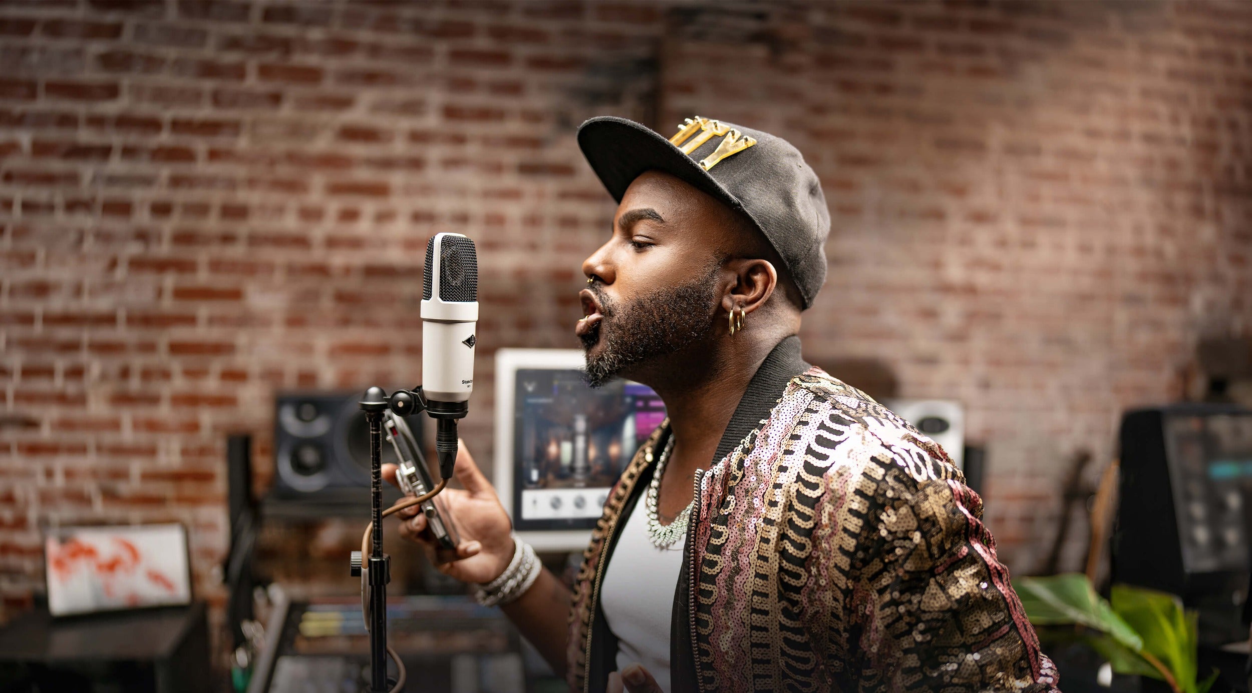 Universal Audio SC-1 condenser microphone shown with its sleek black body and gold grille, ideal for studio recording.