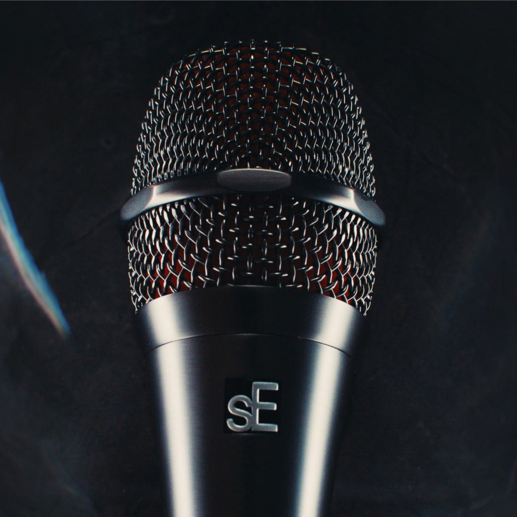 sE Electronics V8 microphone grille and sE badge on a dark stage surface