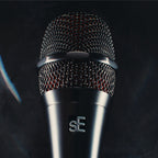 sE Electronics V8 microphone grille and sE badge on a dark stage surface