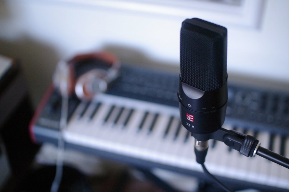 SE Electronics X1 A condenser microphone shown with a metal grille and sleek black body, ideal for studio recording.