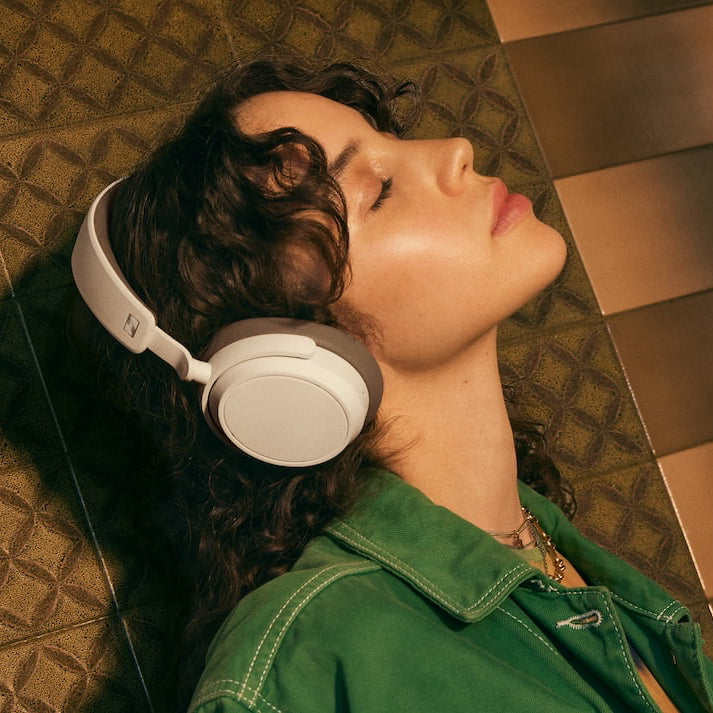 Sennheiser Accentum Plus wireless headphones worn by a woman, showcasing sleek design and comfortable fit for listening on the go.