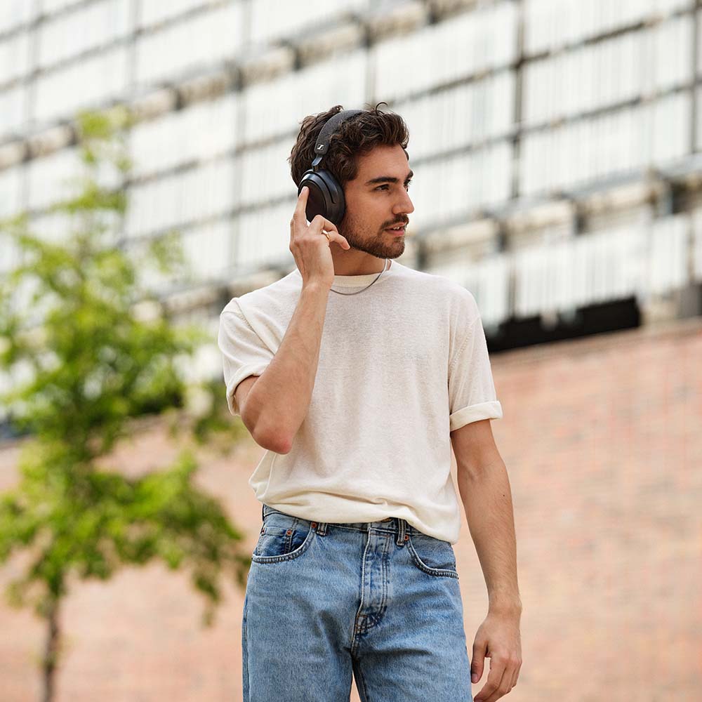 Black Sennheiser Momentum 4 Wireless headphones with touch controls, shown on a man wearing them comfortably.