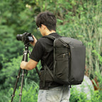 SmallRig Outra 25 backpack worn outdoors with a tripod