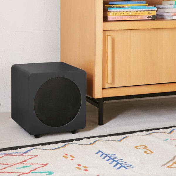 Kanto Audio SUB8V subwoofer showing its sleek black enclosure and front grille with control knobs on top.