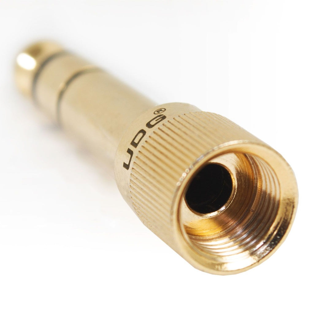 UDG Ultimate Headphone Jack Adapter Screw U94001 connected to headphones, compact black audio adapter for smartphones and devices.
