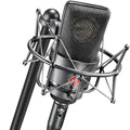 Neumann TLM 103 condenser microphone on a stand, with shock mount and cable, ideal for professional studio recording.