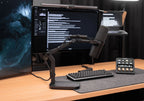 Elgato Wave Desk Stand holding a desktop microphone on a workspace with a laptop and headphones.