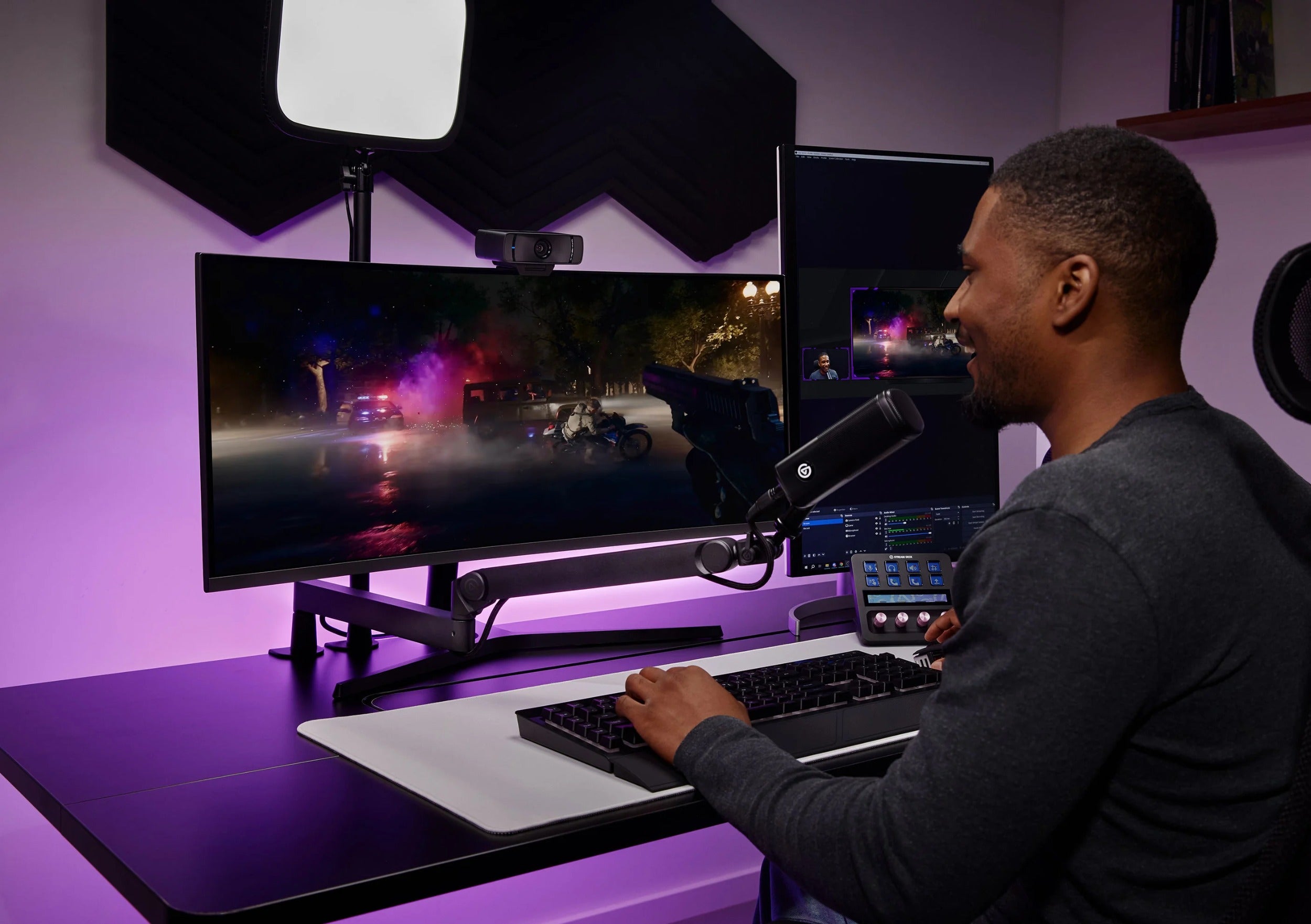 Elgato Wave Mic Arm Pro in black, a professional broadcast microphone arm, shown in a lifestyle setting with microphone attached.