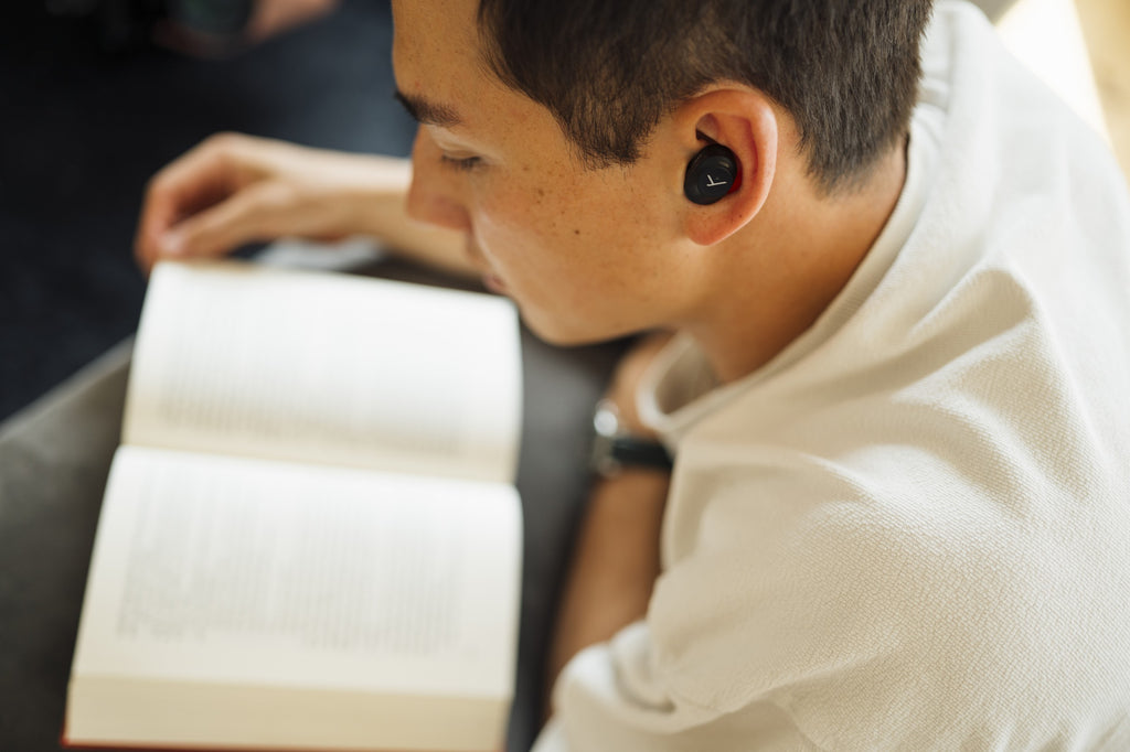Beyerdynamic Amiron 300 wireless in-ear headphones worn by a man at home, showcasing sleek black design and comfortable fit.