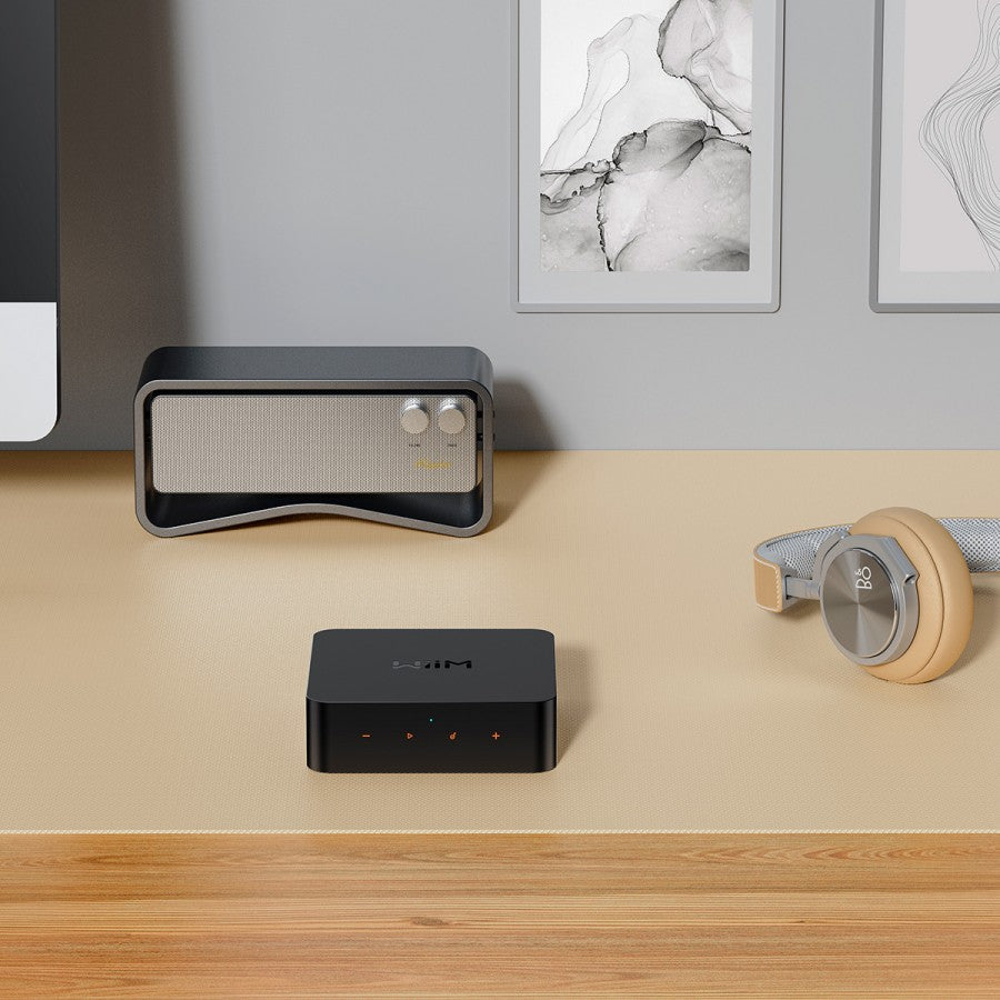 WiiM Pro Plus music streamer device with black and silver design, showing front panel with multiple buttons and display screen.